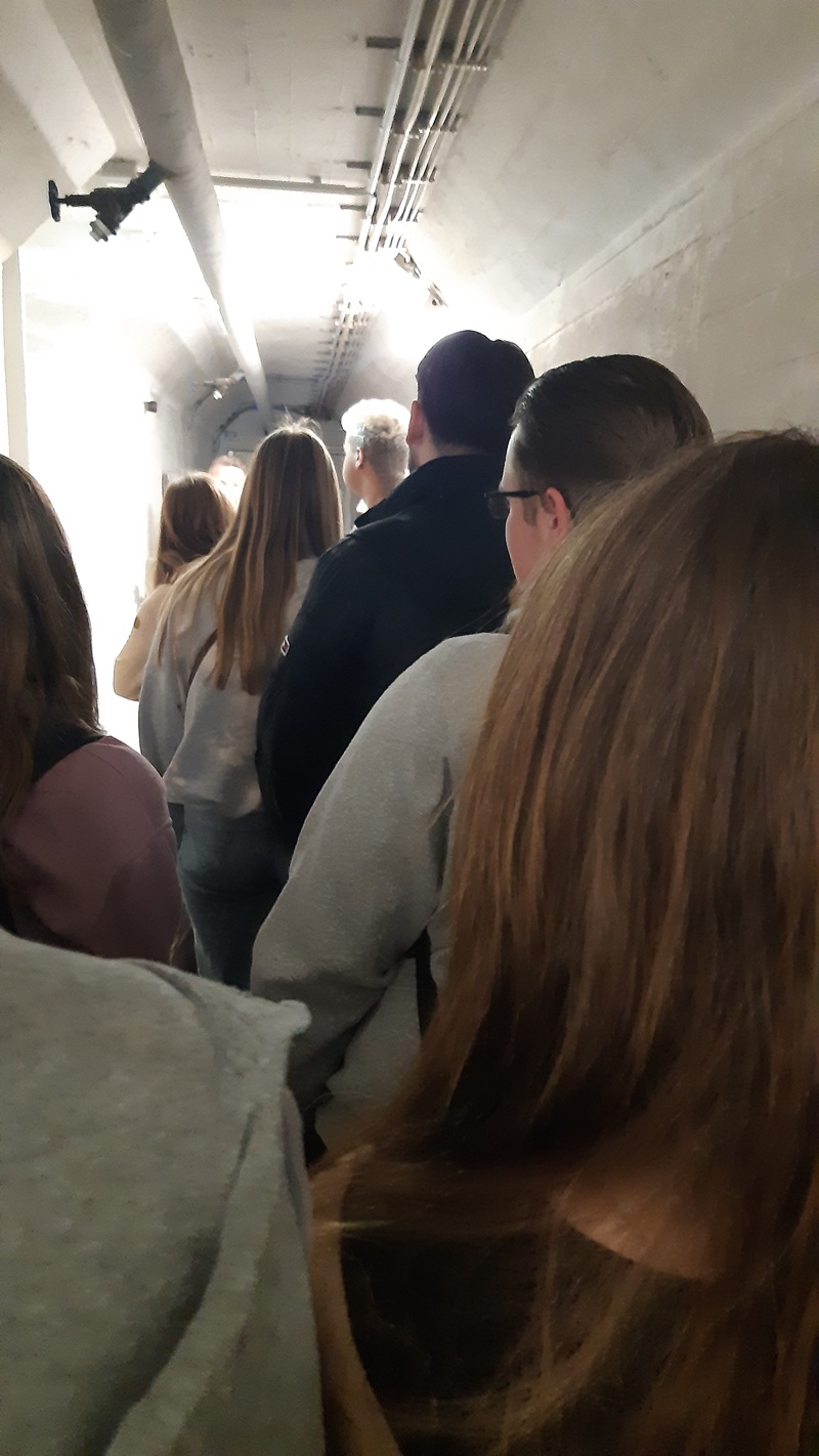 Beeindruckende Zeitreise – 80 Jahre Kriegsende Die Schülerinnen und Schüler der Euro Akademie Aschaffenburg gehen hintereinander in einem schmalen Gang im Schutzbunker.