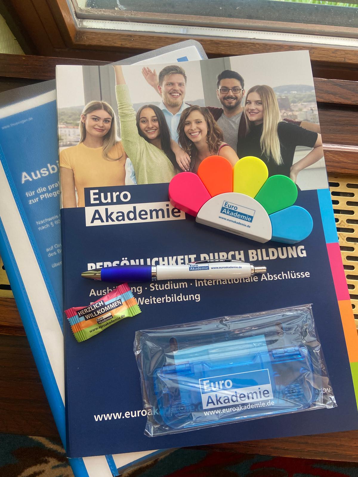 Willkommenspaket: Euro-Akademie-Broschüre, bunte Fächer-Textmarker, Kugelschreiber, Bonbon „Herzlich Willkommen“ und weitere Give-aways.