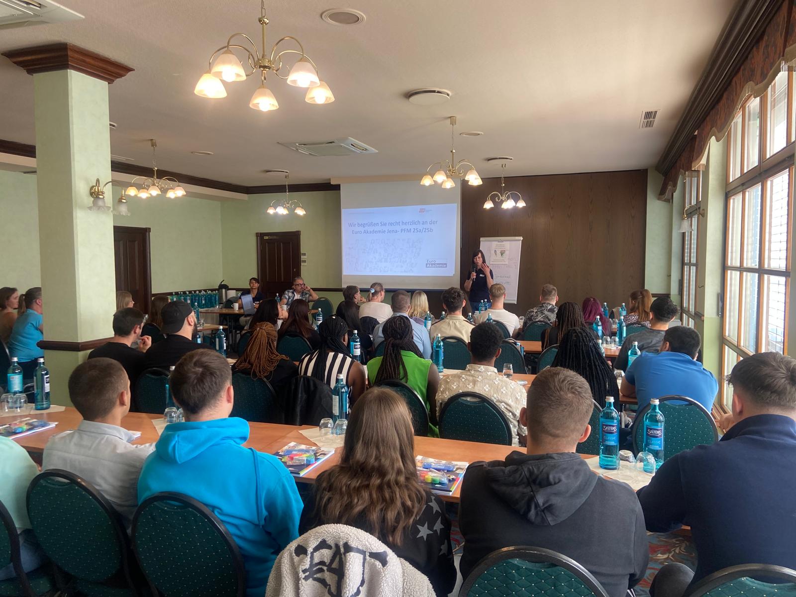 Volles Seminar – Sitzreihen blicken auf eine Referentin und eine Präsentationsfolie der Euro Akademie Jena.
