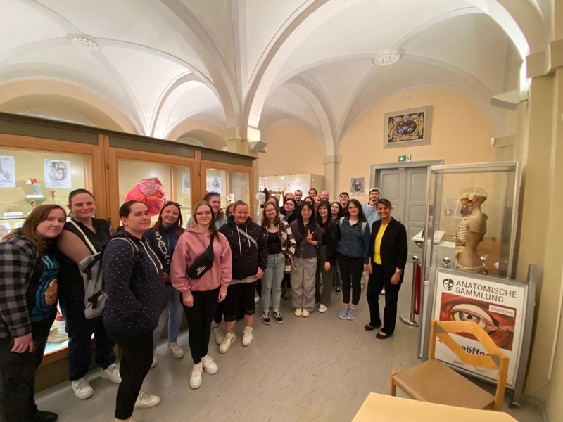 Die rund 25 weiblichen und männlichen Auszubildenden zu Pflegefachkräften an der Euro Akademie Jena  stehen im Ausstellungssaal, mit schönen gewölbten und hohen Decken der Ausstellung Anatomische Sammlung des Universitätsklinikums Jena und posieren lächelnd für ein Gruppenbild.