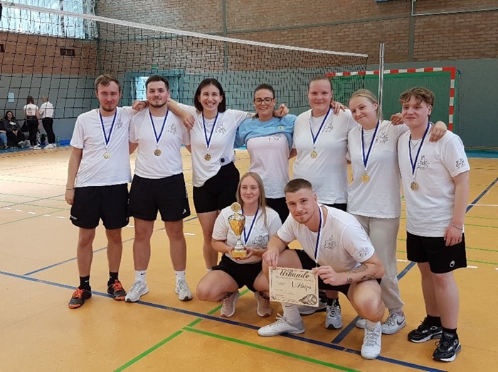 Die Gewinnermannschaft der Azubis posiert mit ihren Medaillen und einem Pokal für ein Gruppenbild.