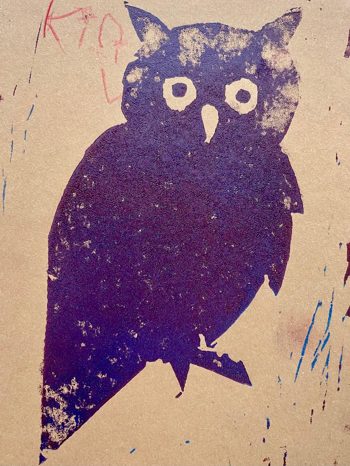 Eulenmotiv als dunkler Druck auf Karton; deutliche Konturen mit Augen und Schnabel, kleine Kritzelspuren am Rand.