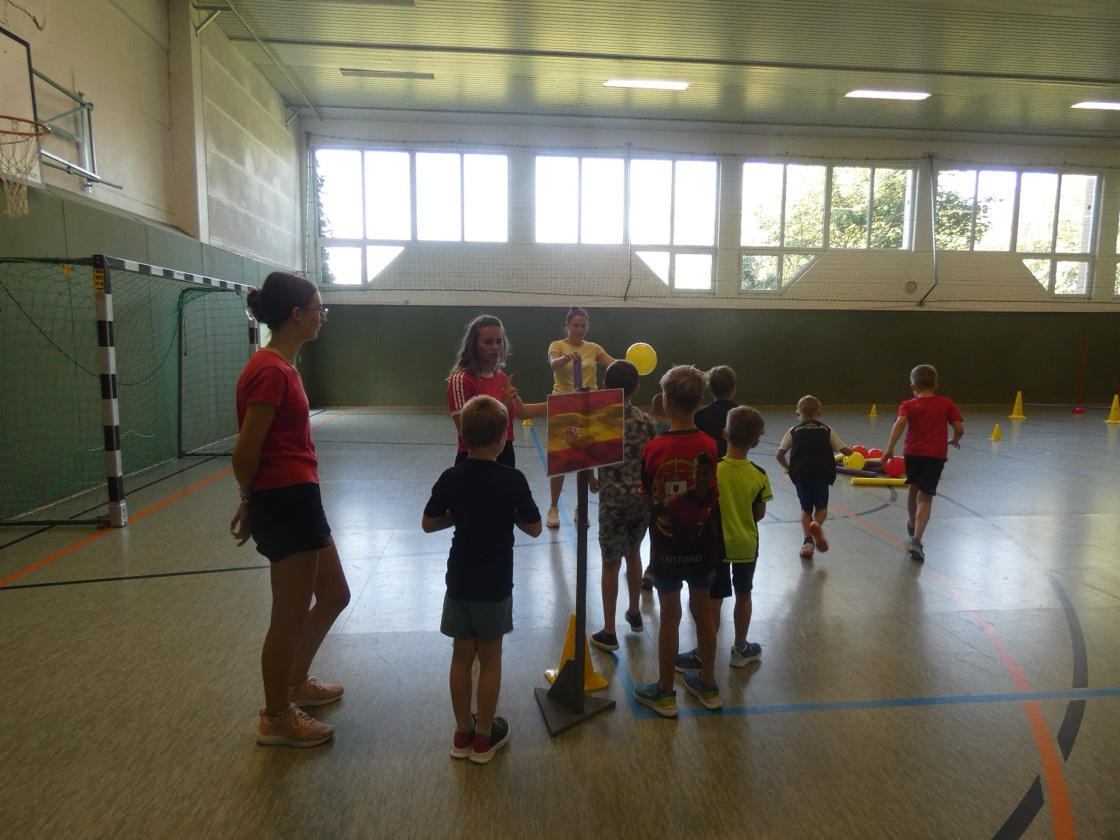 Kinder stehen in der Sporthalle für ein Bewegungsspiel an.