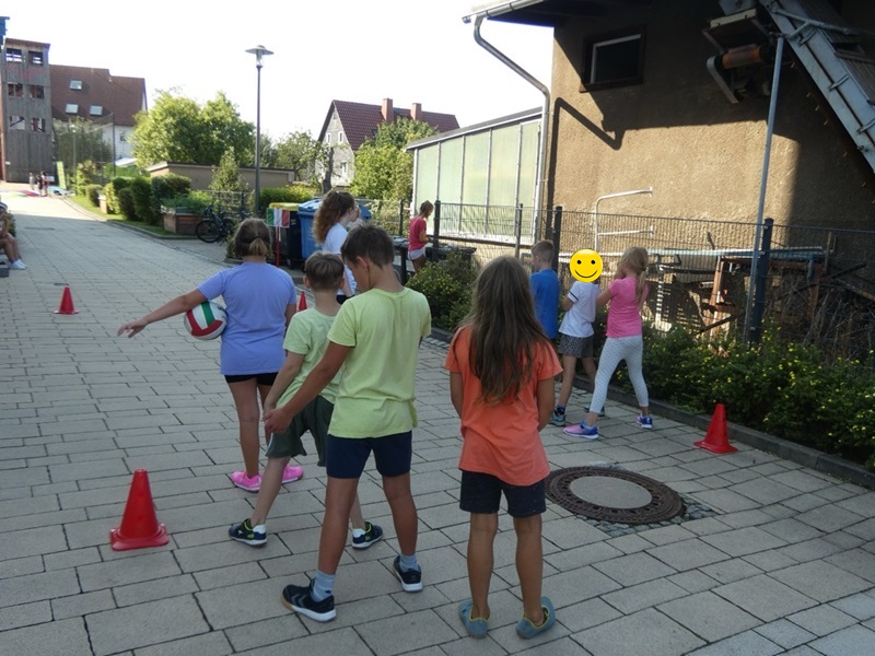 Kinder stehen in zwei Schlagen hintereinander an, um an einem Bewegungsspiel teilzunehmen.