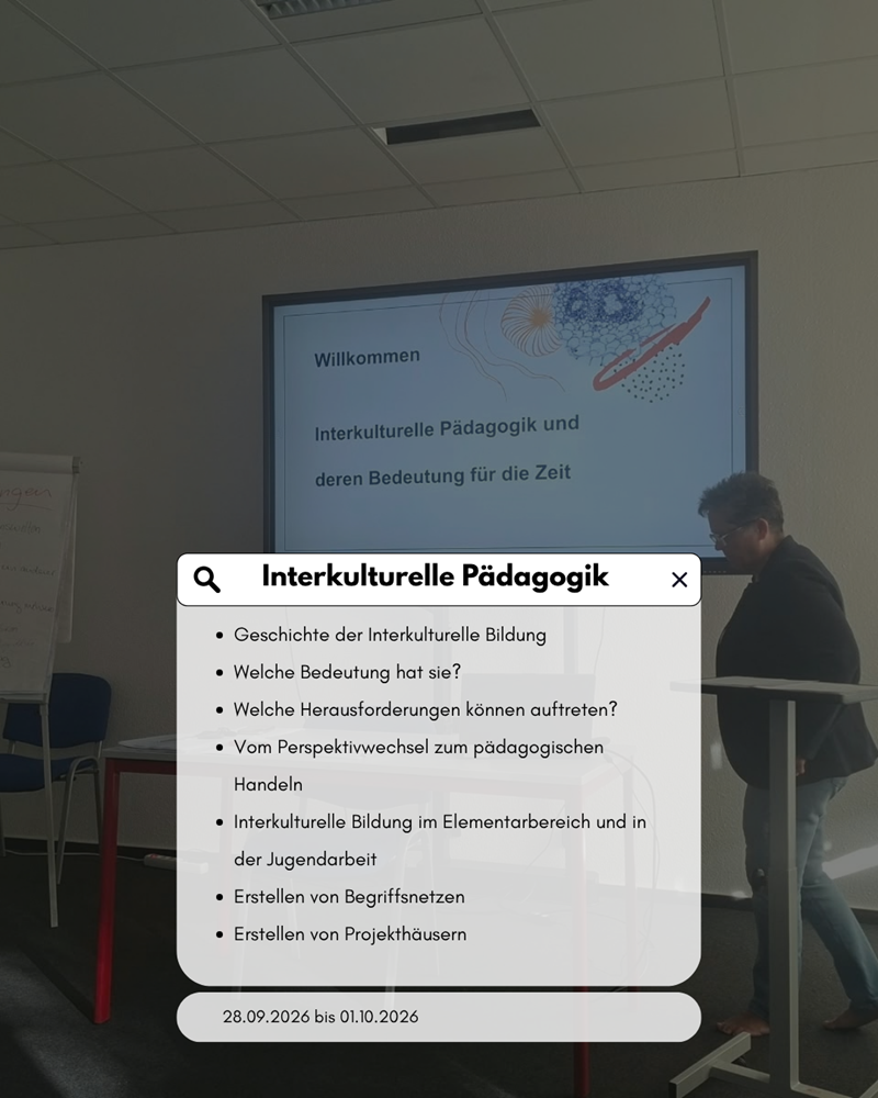 Im Vordergrund steht eine Person an einem Stehpult, die einen Laptop bedient. Im Hintergrund ist eine Präsentationsfolie auf einer Leinwand zu sehen, die den Titel 'Interkulturelle Pädagogik und deren Bedeutung für die Zeit' trägt. Davor ist eine Infografik eingeblendet, die verschiedene Themenbereiche der interkulturellen Pädagogik aufführt, darunter Geschichte, Herausforderungen, Perspektivwechsel, Handeln, Bildung im Elementarbereich und in der Jugendarbeit, Begriffsdefinitionen und Projektarbeit. Die Farbgestaltung ist hell und modern, mit beigen und blauen Akzenten.