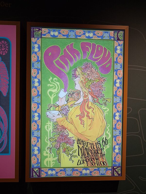 Pink-Floyd-Plakat in leuchtenden Grün- und Lilatönen, im Jugendstil gehalten, mit einer stilisierten Frau mit Blumen im Haar, die eine Tasse hält und Konzertinfos für den 15. März 1966 im Marquee Club London zeigt.