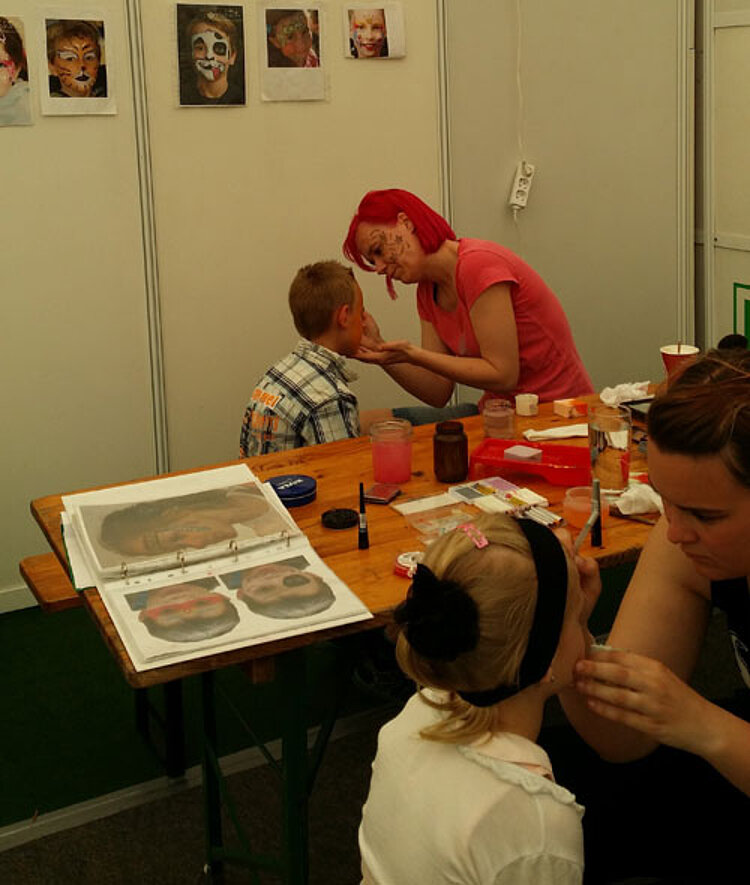Kinderpfleger beim Kinderschminken auf der Gfa Zerbst