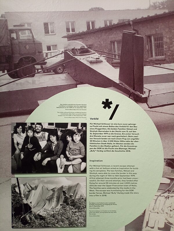 Ausstellungstafel mit historischen Schwarz-Weiß-Fotografien und deutsch-englischen Informationen über eine Flucht aus der DDR mit einem selbstgebauten Heißluftballon.