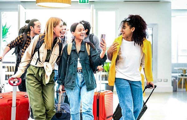 Aufbruch nach Toulouse und Barcelona Schülerinnen und Schüler gut gelaunt, mit Koffern und ein Selfie machend auf dem Weg zum Schüleraustausch.