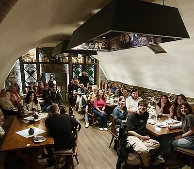 Gruppenfoto des Alumnitreffens der Euro Akademie Aschaffenburg mit allen Teilnehmenden im Restaurant aus der Vogelperspektive.
