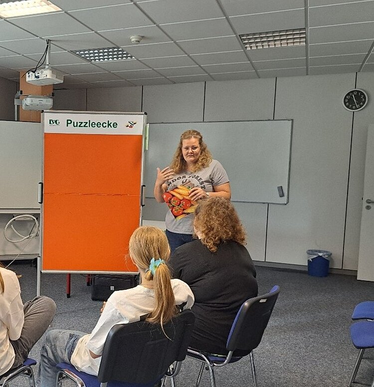 Mit Schwung zu mehr Nachhaltigkeit – ein Parcours macht Schule Die angehenden Sozialassistentinnen und Sozialassistenten der Euro Akademie Magdeburg sitzen im Klassenraum in einem Halbkreis vor einem Flipchart und hören dem Vortrag einer Lehrkraft zu.
