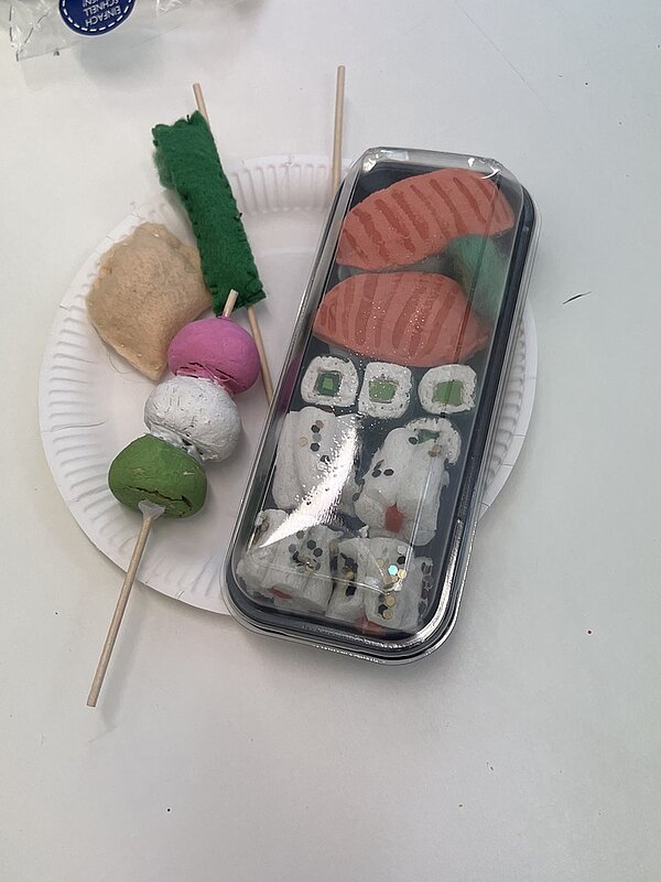 Kunstvoll gestaltete Variation Sushi in repräsentativer und typischer, transparenter Plastikverpackung.