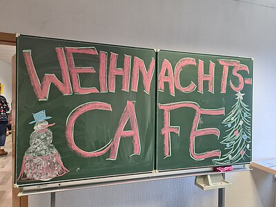 Die Schultafel wurde beschrieben mit dem Wort "Weihnachtscafé"