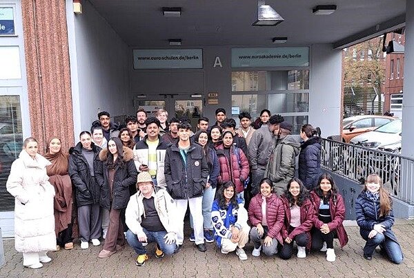 Die neuen Auszubildenden zu Pflegeassistentinnen und -Assistenten posieren draußen für ein gemeinsames Klassenfoto.