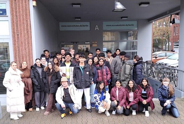 Die neuen Auszubildenden zu Pflegeassistentinnen und -Assistenten posieren draußen für ein gemeinsames Klassenfoto.