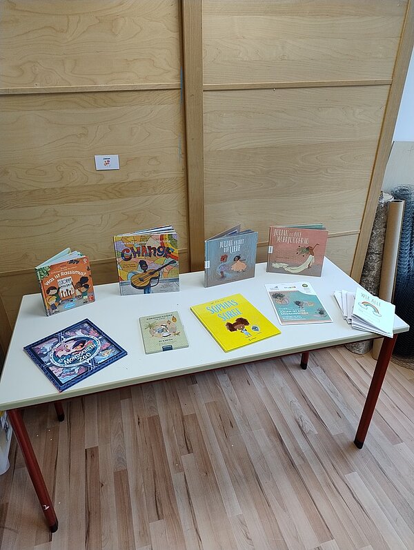 Studierende der Fachschule gestalten eindrucksvolle Ausstellung Auf einem weißen Tisch stehen acht ausgewählte Kinderbücher.
