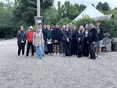 Die Auszubildenden der Euro Akademie Tauberbischofsheim posieren gemeinsam outddor vor dem Wildpark für ein Gruppenfoto.