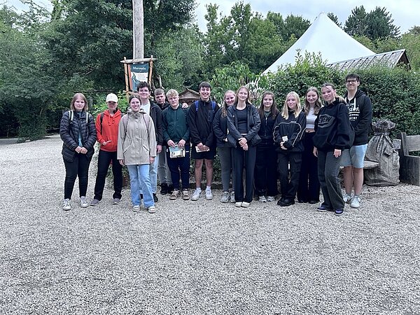 Die Auszubildenden der Euro Akademie Tauberbischofsheim posieren gemeinsam outddor vor dem Wildpark für ein Gruppenfoto.
