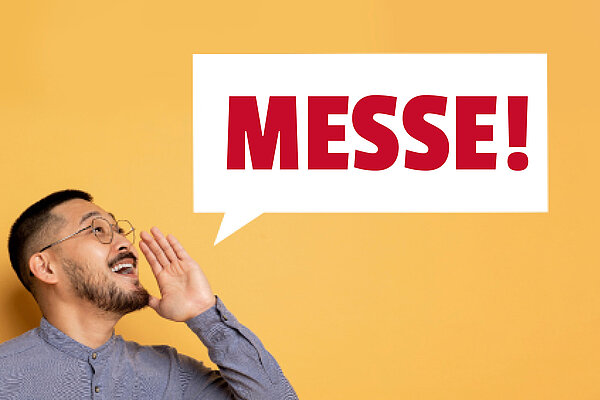 Messe: vocatium Magdeburg 2025 11. und 12.06.2025 Die Aufschrift "Messe!" in großen roten Lettern befindet sich in einer weißen rechteckigen Sprechblase. Links unten ist der Kopf eines Mannes mit geöffnetem Mund zu sehen, der eine Hand wie zum Ausruf erhoben hat.