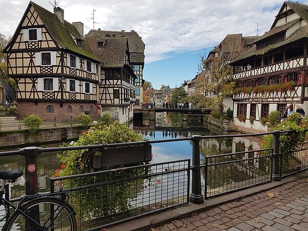 Brücke über den Fluss Ill mit Sicht auf Fachwerkhäuser.
