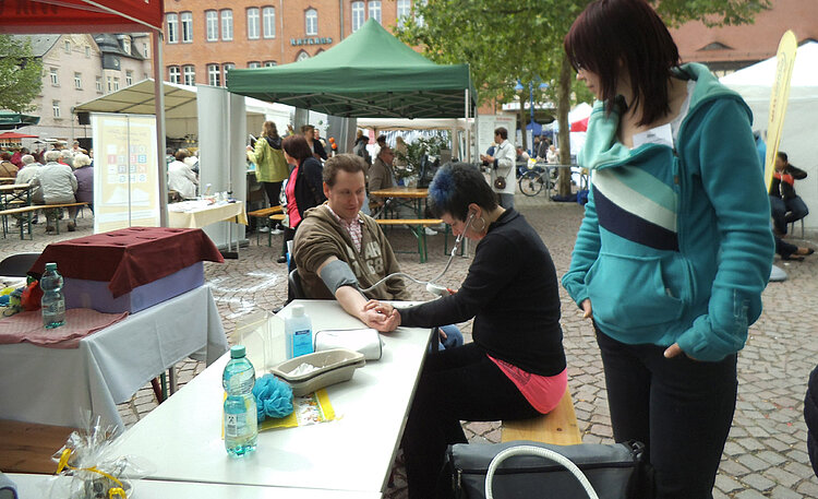 Klasse der Altenpflegehelfer mit Stand auf dem Seniorenmarkt