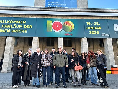 Schülergruppe vor dem Eingang einer Messehalle, darüber ein Banner mit den Worten "Jubiläum" und "100 Jahre"