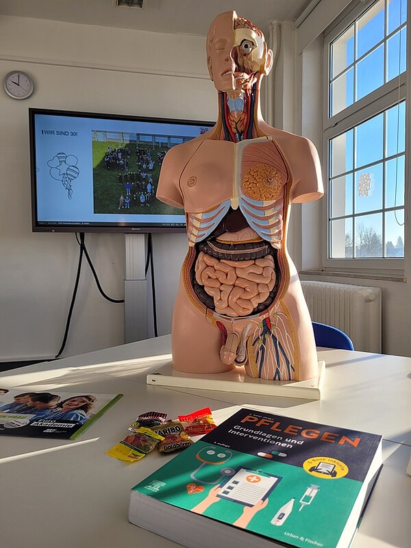 Geöffneter Platik-Torso eines Menschen im Klassenraum auf dem Tisch. 