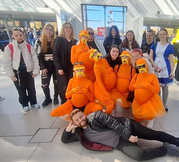 Exkursion zur Buchmesse Leipzig Die gute gelaunten Auszubildenden der Euro Akademie Dessau posieren auf der Leipziger Buchmesse für ein Gruppenfoto. Einige der Azubis haben sich mithilfe von tollen Kostümen als Lorex verkleidet.