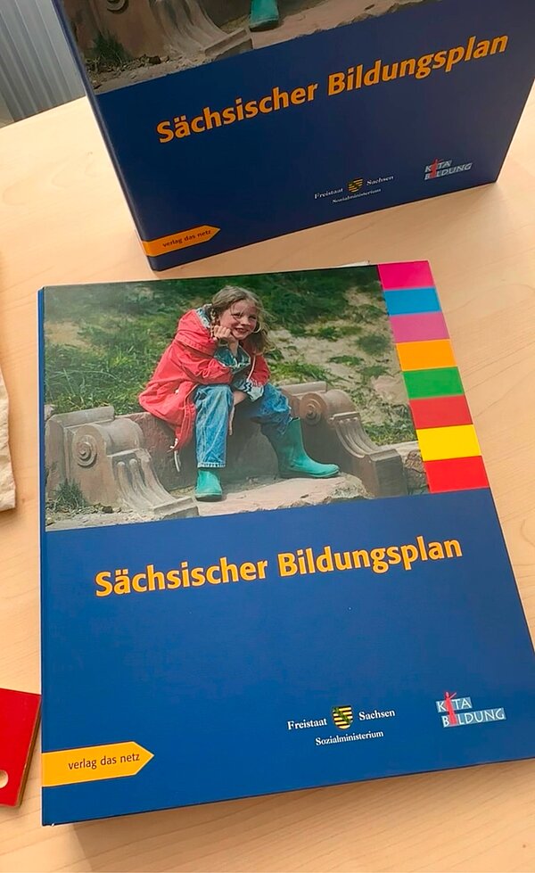 SCHAU REIN! – Woche der offenen Unternehmen Sachsen Ein Tisch mit vorbereiteten Materialien: Kugelschreiber, Haftnotizen in verschiedenen Farben, Broschüren und Süßigkeiten, bereit für eine Veranstaltung oder einen Workshop.