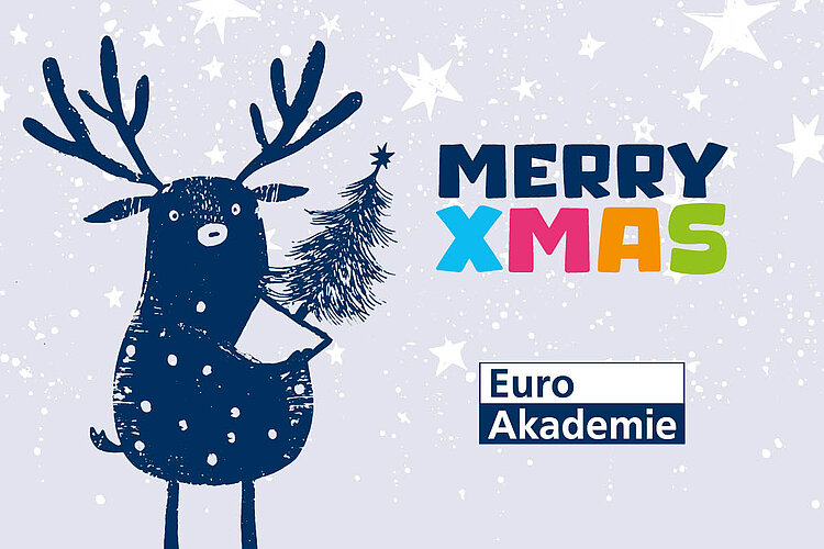 Graublaue Schneekarte: gepunktetes Rentier trägt kleines Tannenbäumchen; Schrift „MERRY XMAS“; Logo Euro Akademie unten rechts.