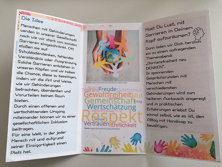 Praktikumsvorbereitungen der Sozialassistent*innen Flyer mit orangenen oder blauen Hintergrund liegen auf einer weißen Tischplatte. Inhaltlich wurden die Flyer von den Sozialassistent*innen erarbeitet und handeln von Barrierefreiheit.