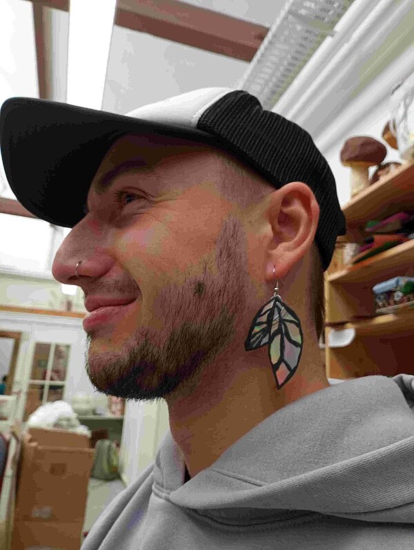 Schüler trägt einen selbst recycelten und gestalteten Ohrring.