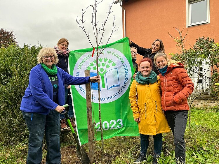 Gruppenfoto vor dem neu gepflanzten Mehlbeeren-Baum.