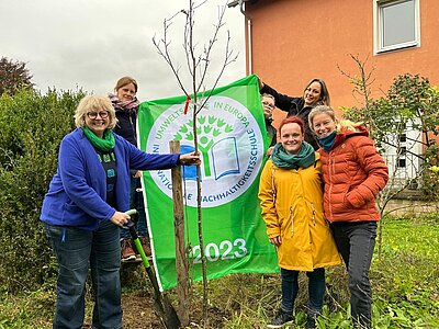 Gruppenfoto vor dem neu gepflanzten Mehlbeeren-Baum.