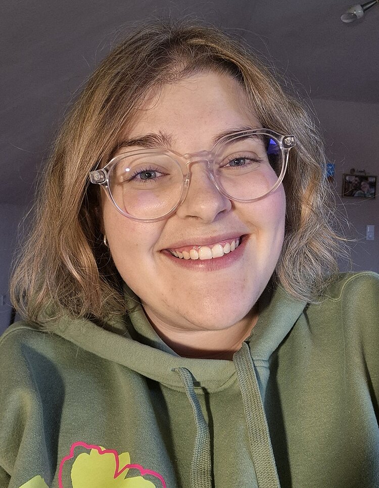 Alumni im Gespräch: Interview mit Lorena Gatani Absolventin Lorena Gatani in grünem Hoodie mit Brille und lächelnd
