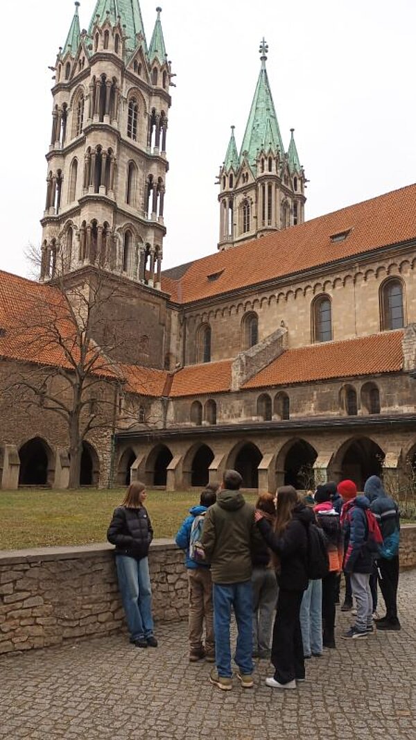 Winter-Sprachferien 2025: „Living in Fairy Tales“ Eine Schülergruppe steht vor einem imposanten Gebäude mit zwei Türmen, dem Naumburger Dom.