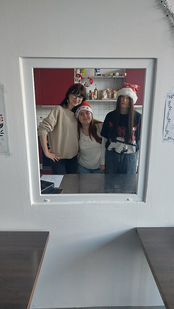 Weihnachtsfeier in Erfurt Portrait von drei Schülerinnen mit Weihnachtsmütze.