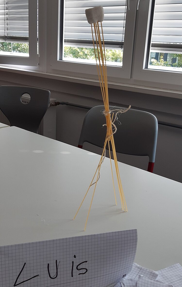 Die “Marshmallow Challenge 2.0” Marshmallow-Turm, der mit langen Spaghetti und Bändern zusammengebaut wurde.