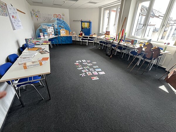 Tag der offenen Tür Im Klassenraum sind die Tische an die Wand geschoben, zu sehen sind Steckenpferde, ein Puppentheater und vieles mehr.
