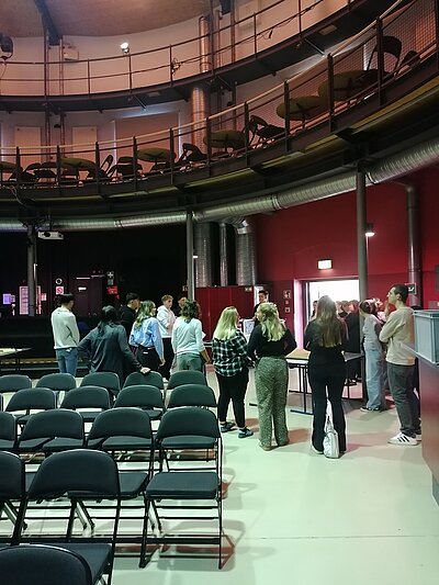 Blick in den großen Saal des Alten Gasometers. Es sind die eingeladenen Schülerinnen und Schüler zu sehen, die gleich ihre Plätze einnehmen zur Filmvorführung.