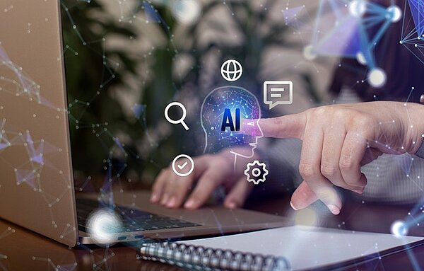 KI im Klassenzimmer Frauenhand zeigt auf den Bildschirm eines Laptops und nutzt KI Technologien.