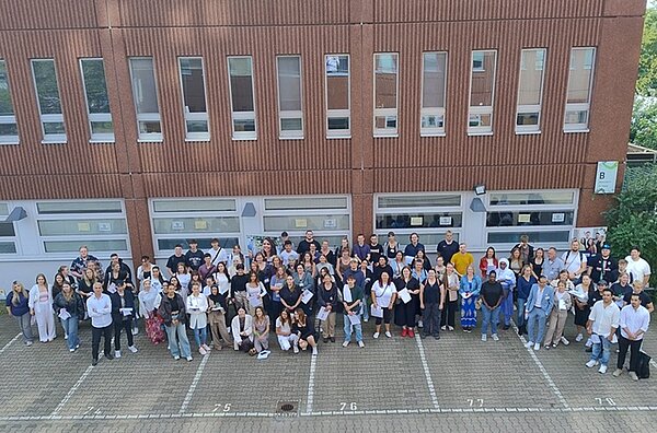Feierliche Zeremonie zum Ausbildungsstart Gruppenbild aller neuen Auszubildenden vor dem Gebäude der Euro Akademie aus der Vogelperspektive.