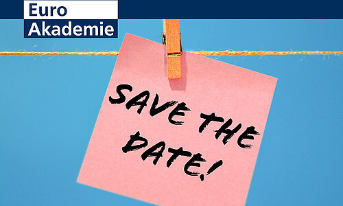 Die Aufschrift "Save the Date!" steht wie handschriftlich geschrieben auf einem rosafarbenen Notizzettel, der mit einer Holzwäscheklammer an eine Kordel gehängt ist. Der Hintergrund ist blau. Links oben befindet sich das Logo der Euro Akademie.