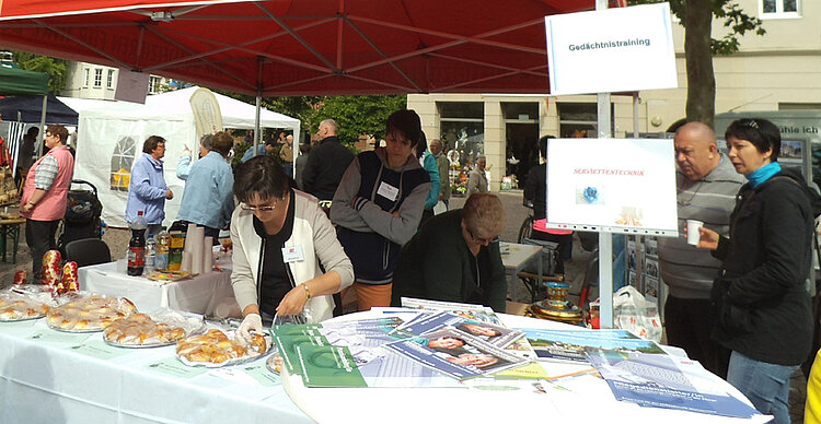 Klasse der Altenpflegehelfer mit Stand auf dem Seniorenmarkt