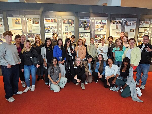 Anatomie hautnah erlebt – Ein unvergesslicher Ausflug ins Plastinarium! Gruppenfoto der Ausbildungsklassen der Euro Akademie Görlitz vor Informationstafeln im Plastinarium.