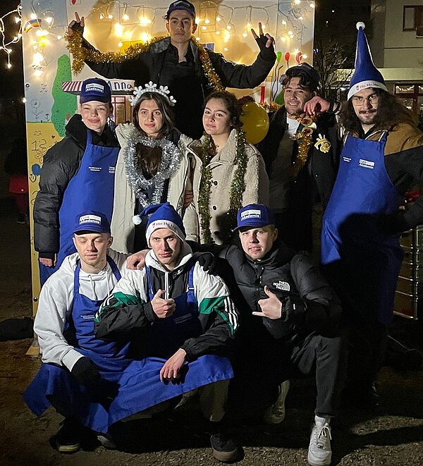 Euro Akademie Berlin begeistert beim Wintermarkt Schülerinnen und Schüler posieren in Weihnachtsmontur für ein Gruppenbild.