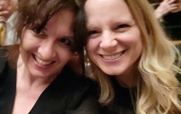 All That Jazz! Englischunterricht im Opernhaus Hannover Zwei Frauen sitzen nah beieinander und machen ein Selfie. Beide lächeln herzlich in die Kamera.