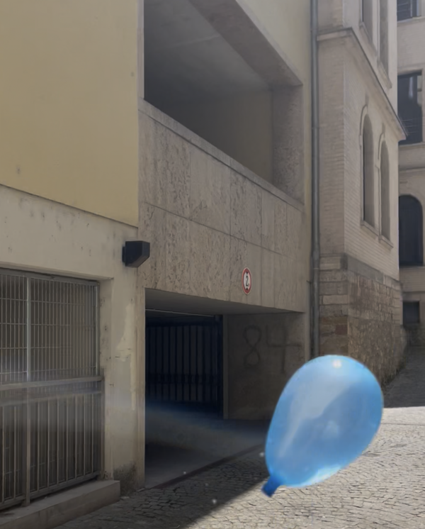 Ein blauer Wasserballon schwebt in einer engen Gasse vor einem Parkhaus-Eingang mit der Hausnummer 84. Die Szene ist von Sonnenlicht durchflutet.