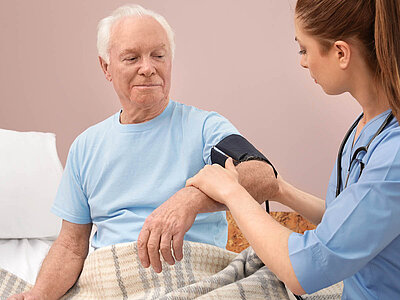 Eine Krankenschwester misst den Blutdruck eines Patienten, eine gängige medizinische Prozedur.