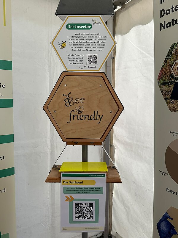 Holzgehäuse „Bee friendly“ mit Informationstafel und QR-Codes zu einem Insekten-Monitoringsystem.